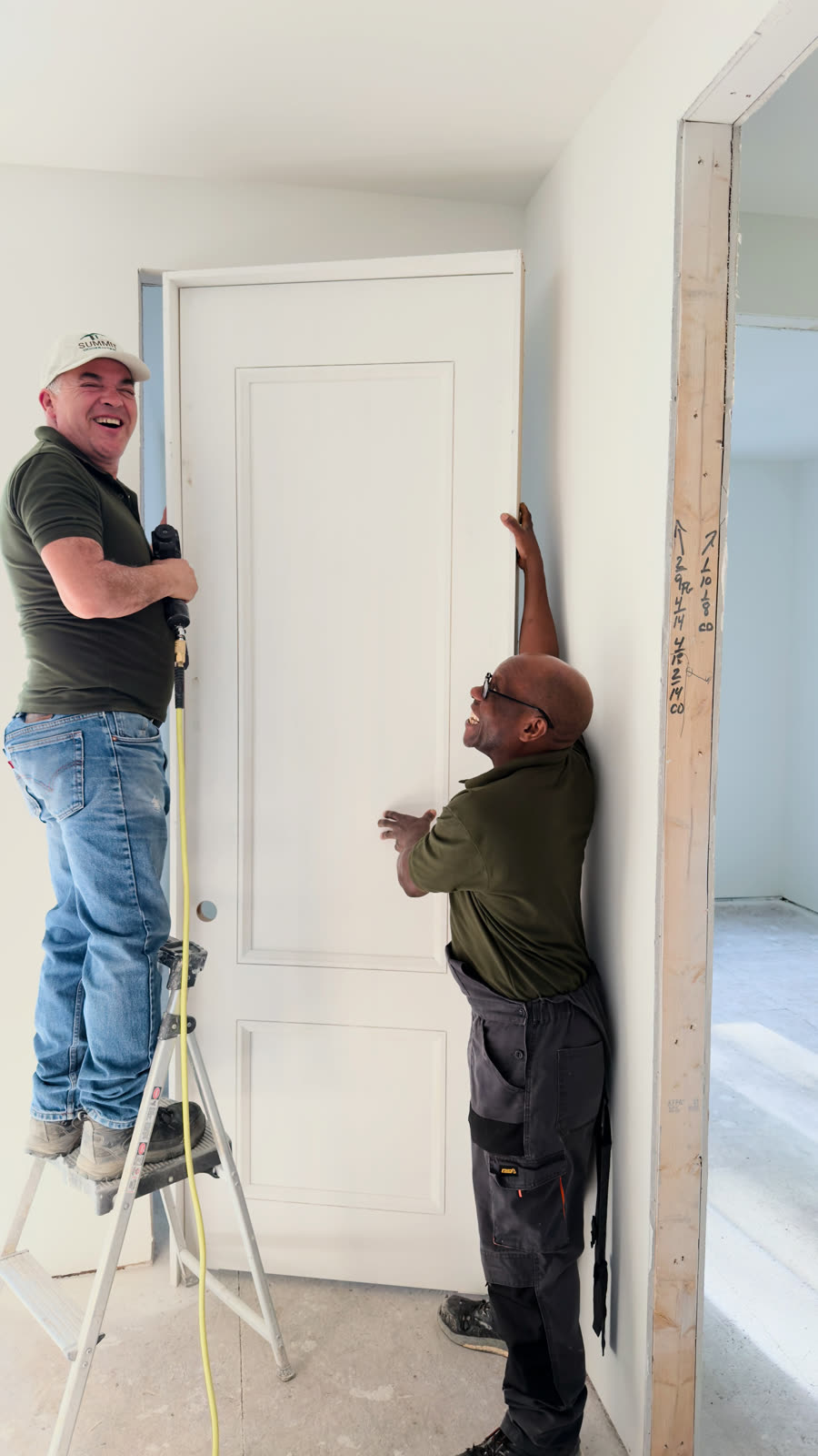 Summit installers hanging a door in a newly framed space